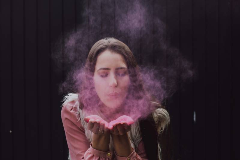 A woman blowing smoke, a common air pollutant.